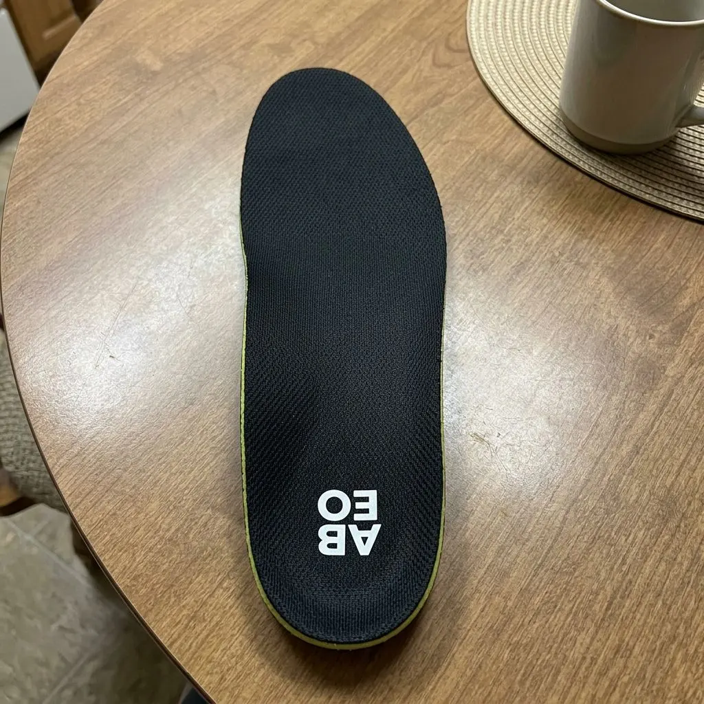 ABEO Premium Orthotic insole viewed from above, showing the black top cover and ABEO logo