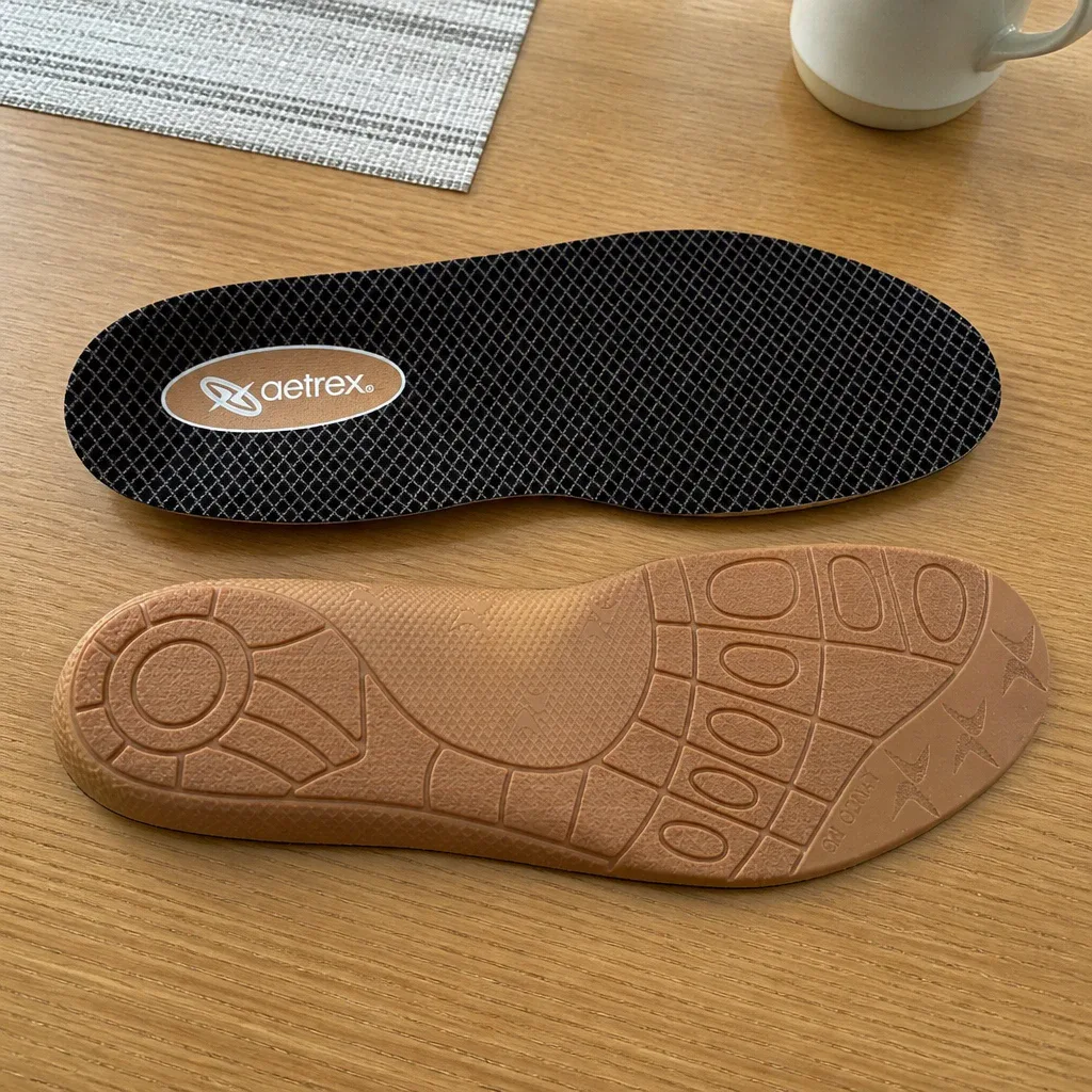 A pair of Aetrex Lynco L400 Compete orthotic insoles laid flat on a kitchen table