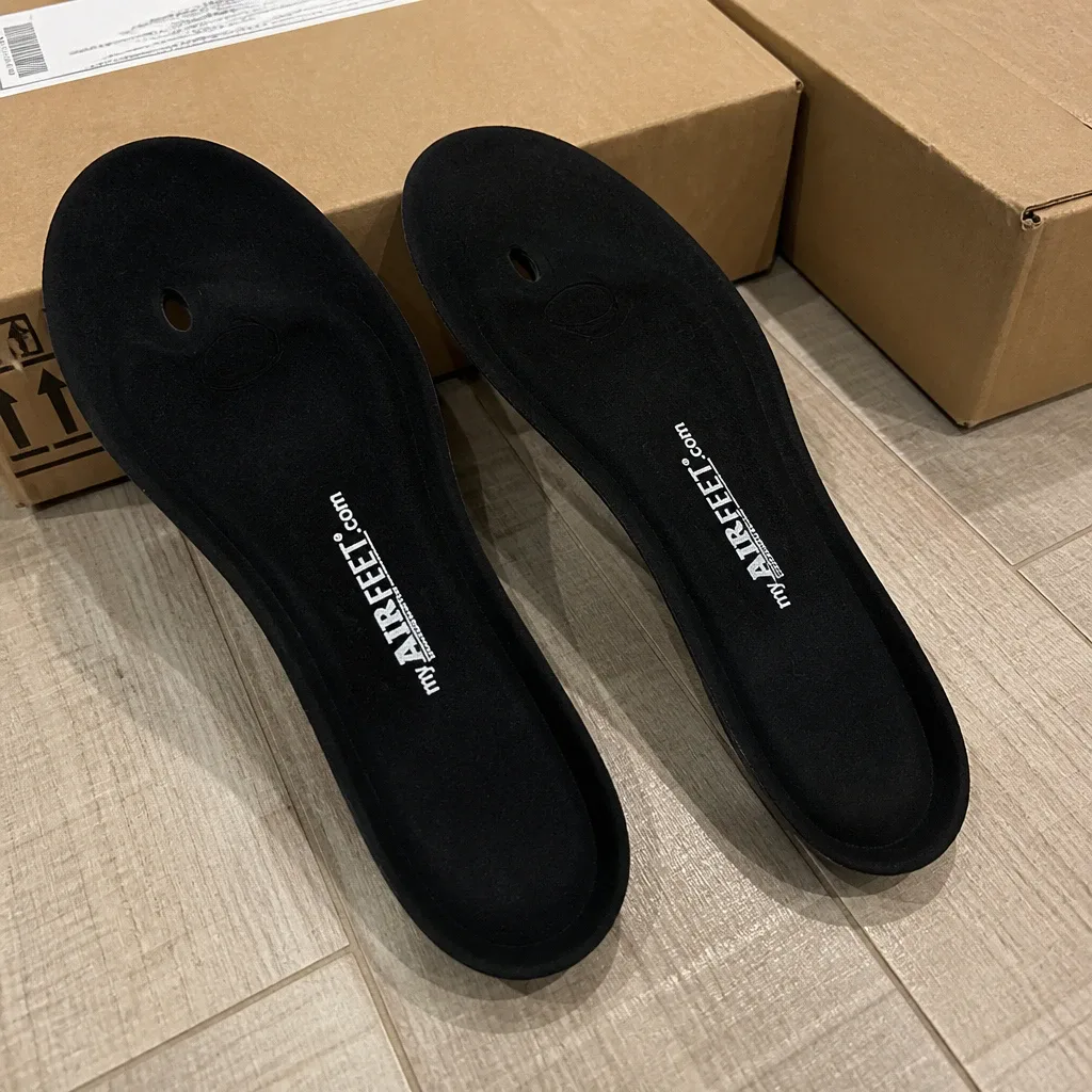 A pair of AirFeet Classic O2 insoles next to their retail box on the floor