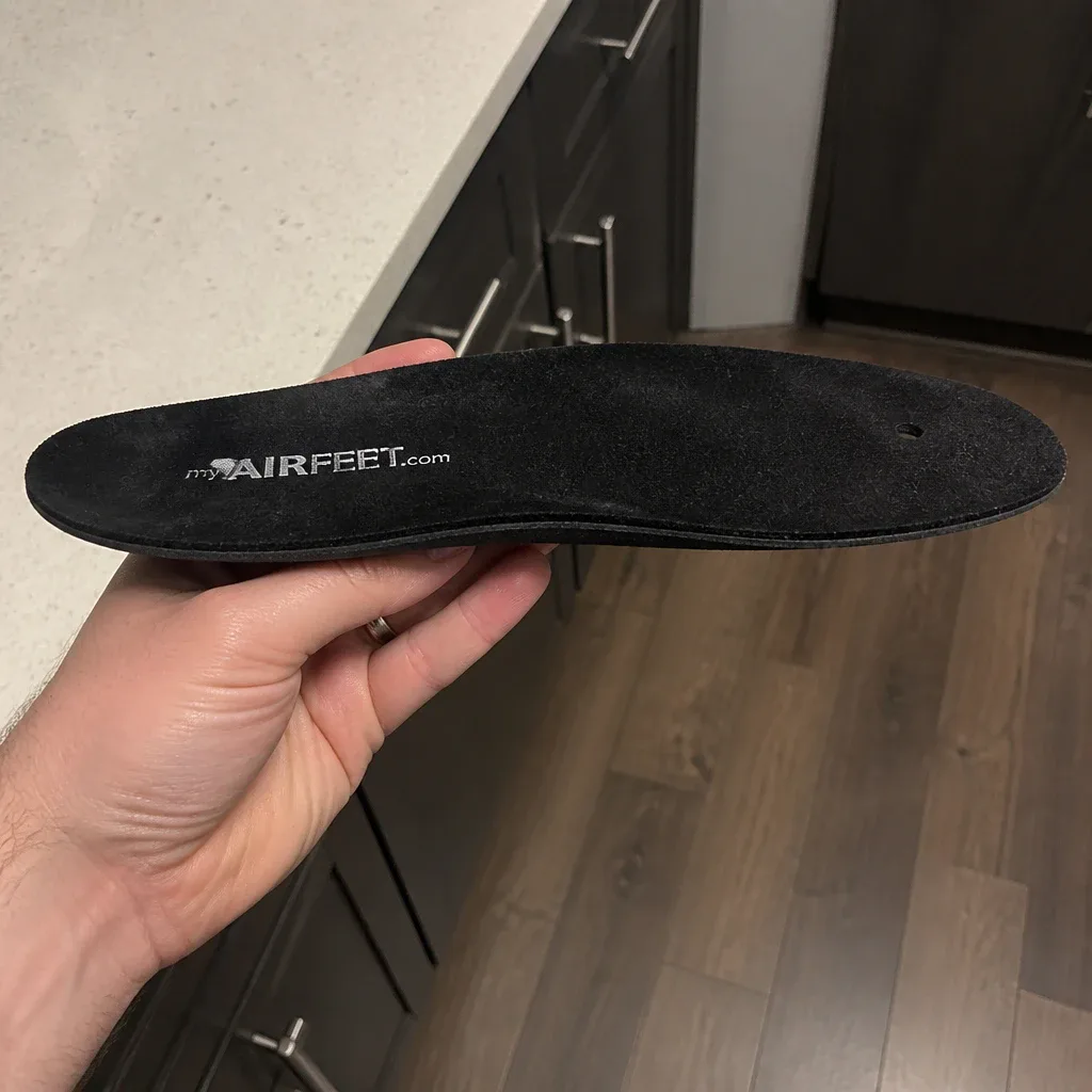 A side view of an AirFeet Classic O2 insole held in hand, showing the 1.7mm gel profile