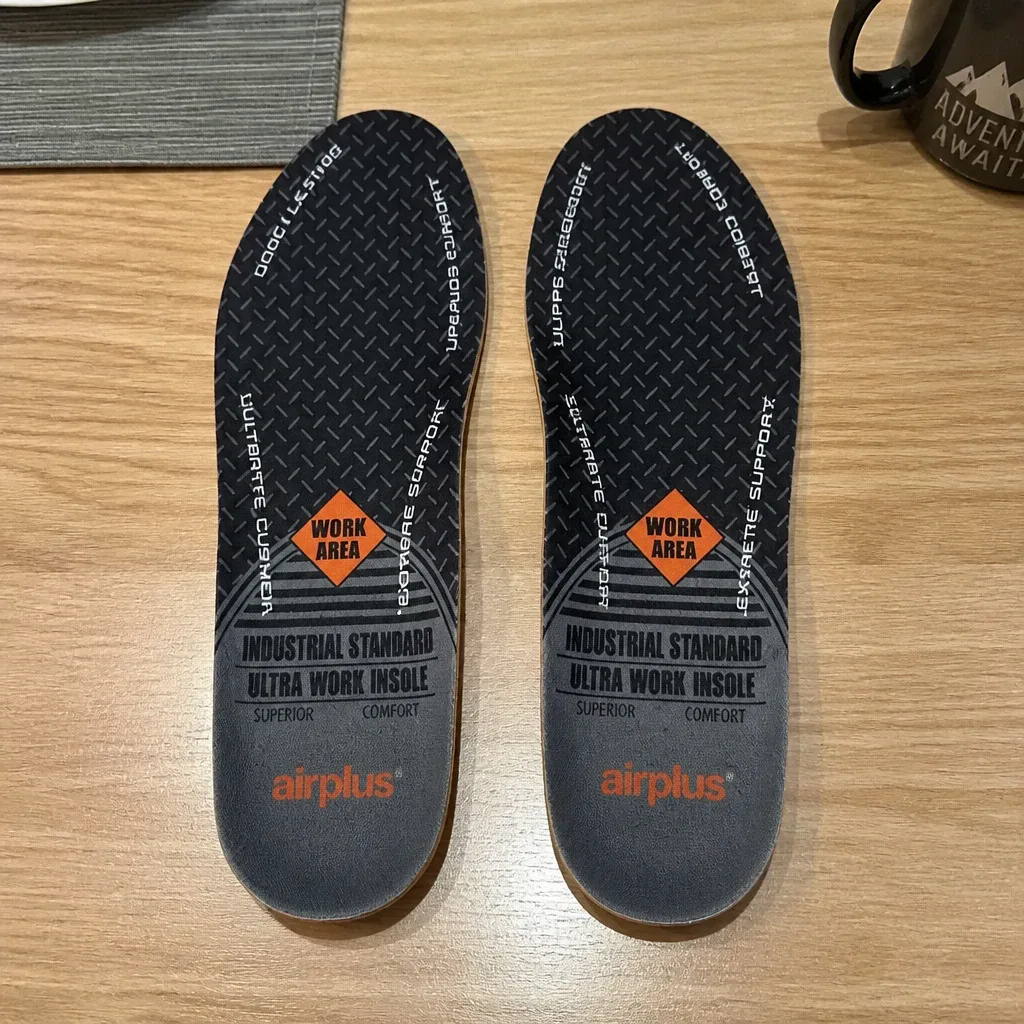 A pair of Airplus Ultra Work Memory Plus insoles laid out on a kitchen table next to their retail box
