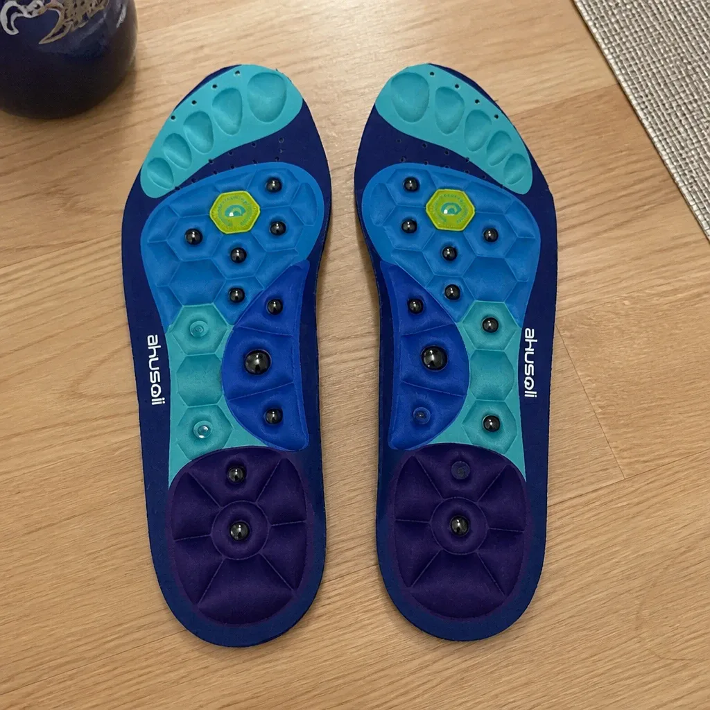 A pair of Akusoli magnetic acupressure insoles laid flat on a kitchen table