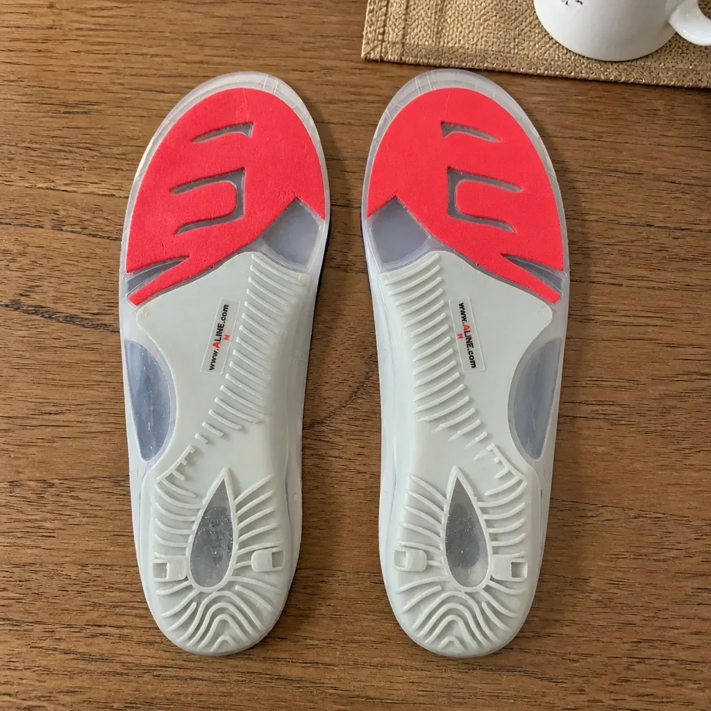 Aline Red All Day insoles resting on a kitchen table next to the shoes they were fitted into