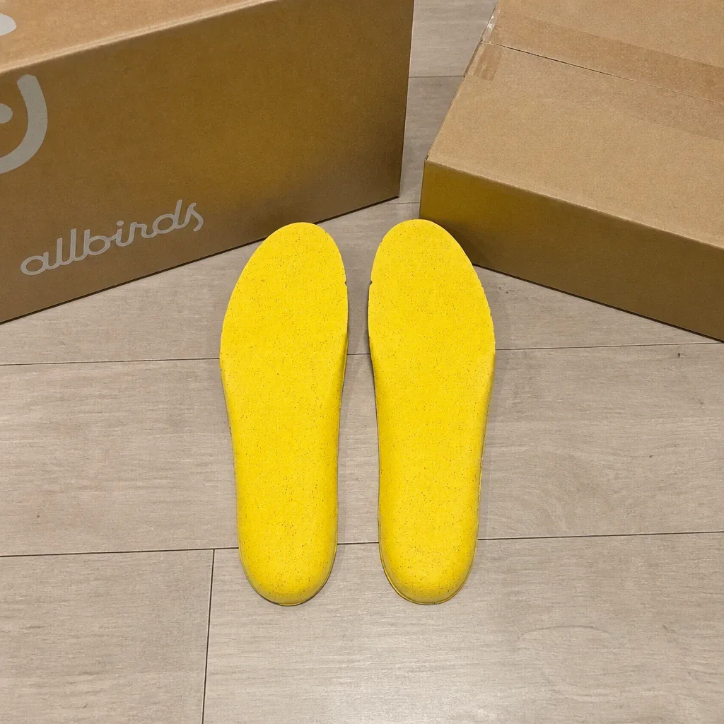 Allbirds Featherbed insoles laid out next to their retail boxes