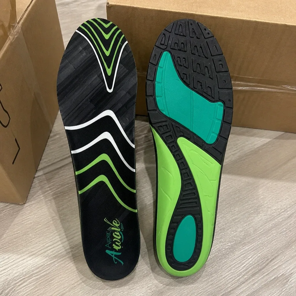 A pair of Apex A-Wave Firm orthotic insoles next to their retail box on the floor