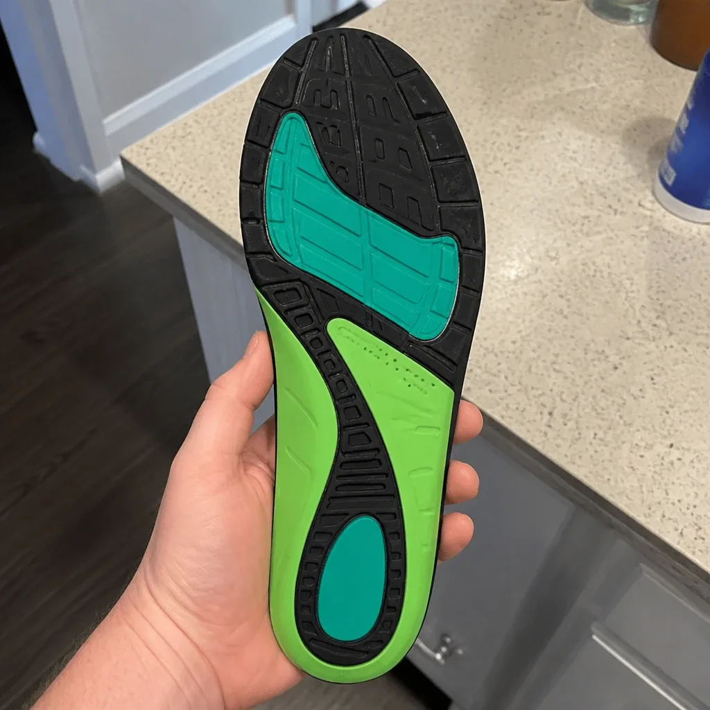 An Apex A-Wave Firm orthotic insole held in hand from a different angle