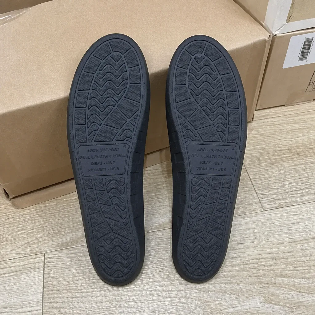 A pair of Archies Full-Length Casual arch support insoles next to their retail box on the floor