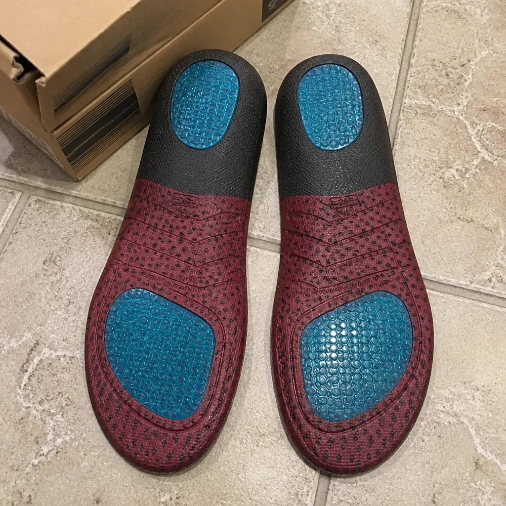 Ariat ATS Wide Square Toe insoles next to their retail packaging on the floor