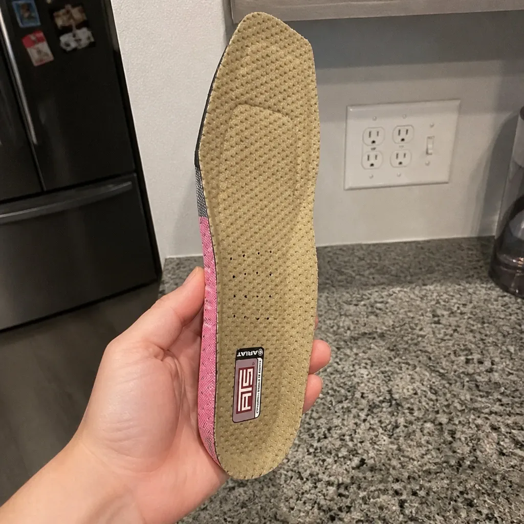 An Ariat ATS Wide Square Toe insole held in hand, showing the gel heel pad