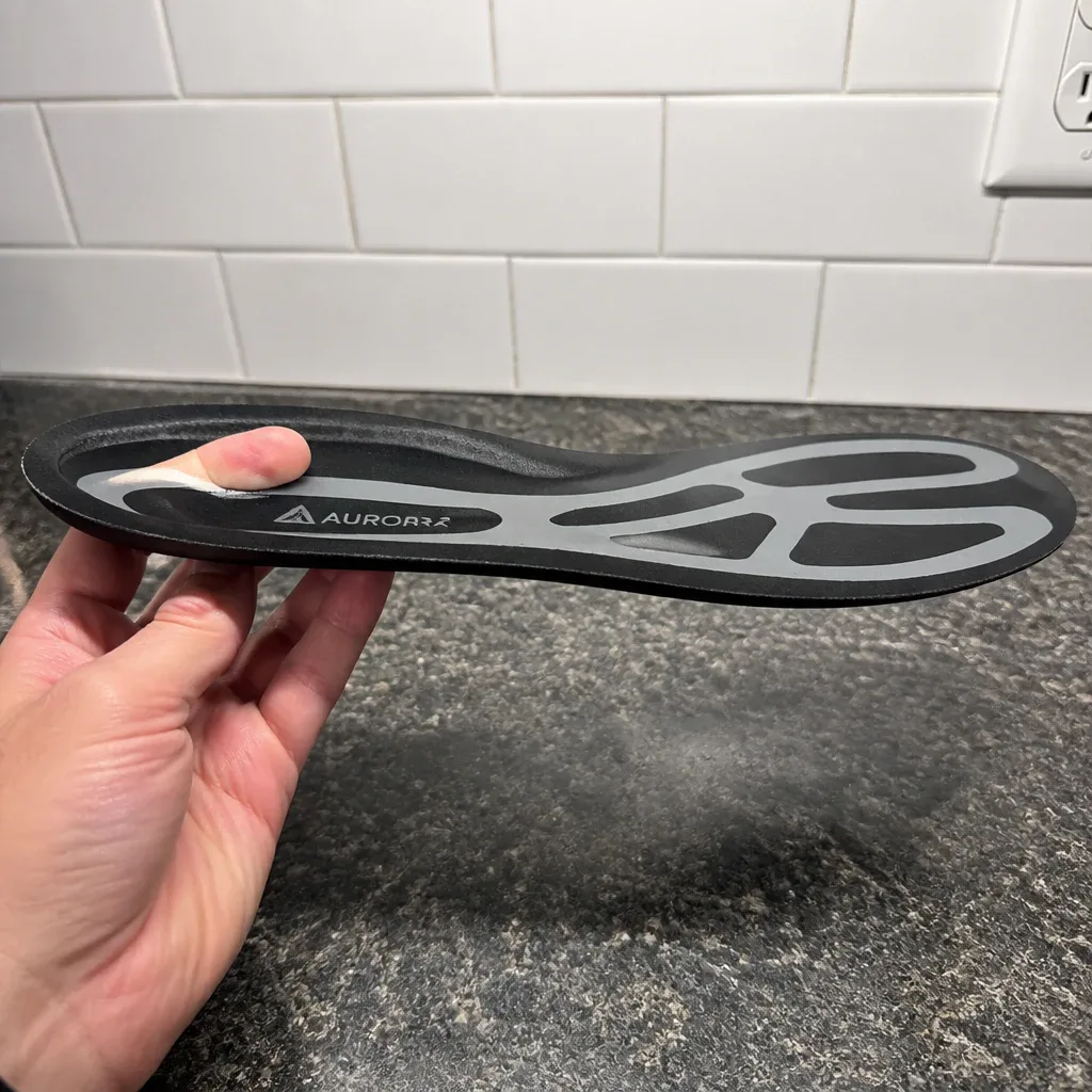 An Aurorra by ARRIS Super Insole held sideways to show the plate profile