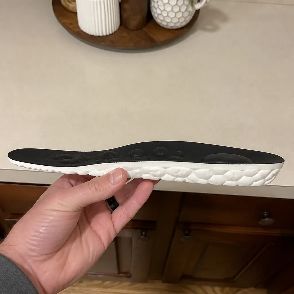 A Back9Relief Golfer's Comfort Insole viewed from the side, showing arch height