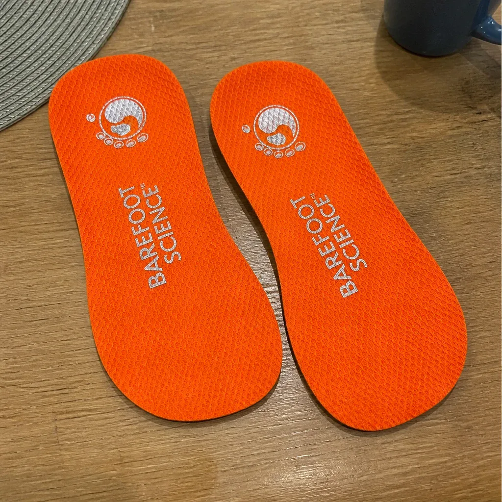 A pair of Barefoot Science insoles laid flat on a kitchen table