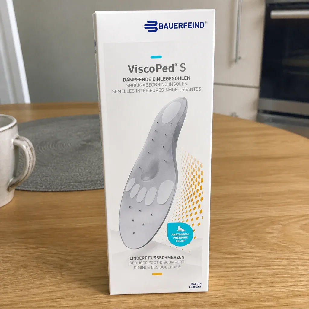 The Bauerfeind ViscoPed S retail box next to the insoles on a kitchen table