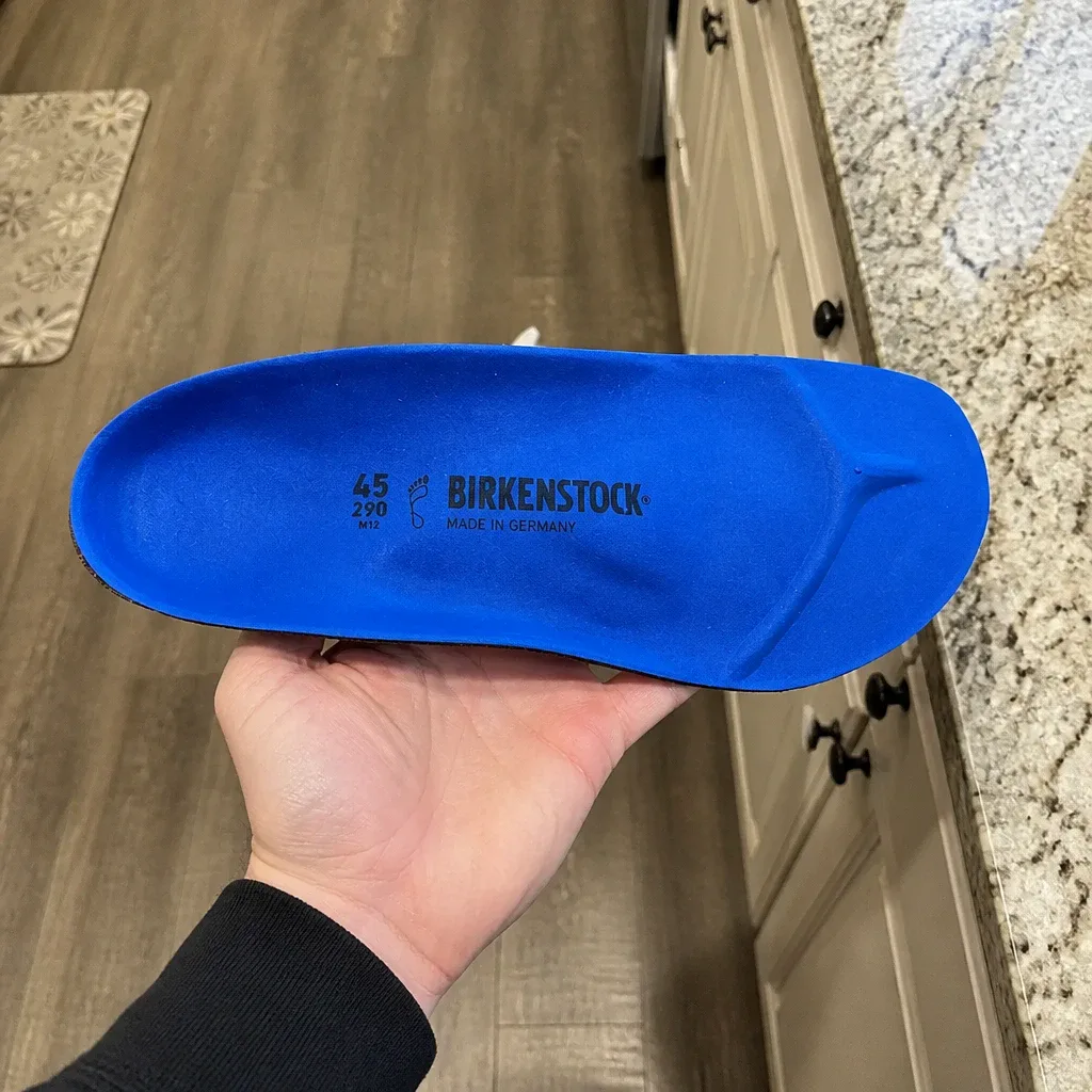 A Birkenstock Birko Sport insole held in hand, showing the foam top-cushion and metatarsal padding