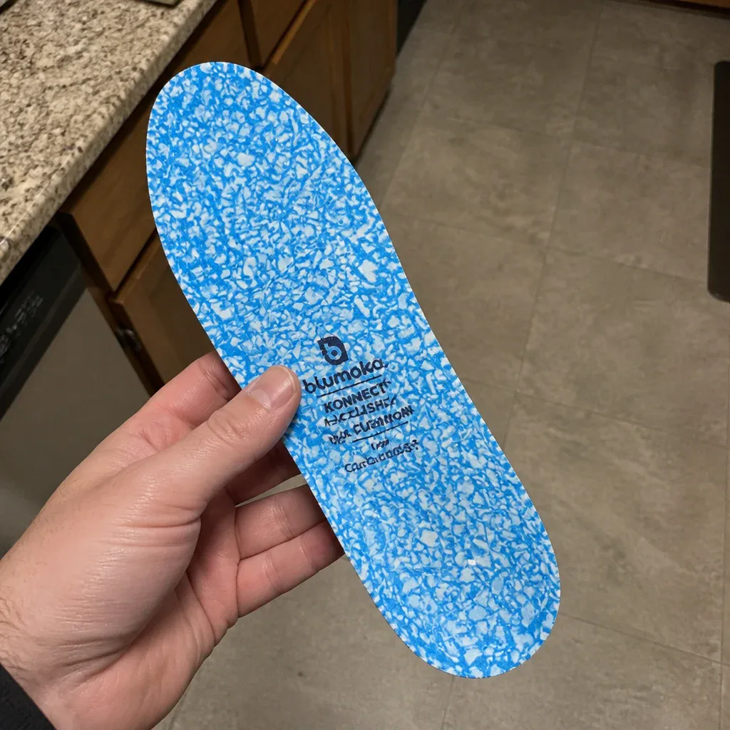 A Blumaka NonSlip Performance Insole held in hand, showing the top cover and foam midlayer
