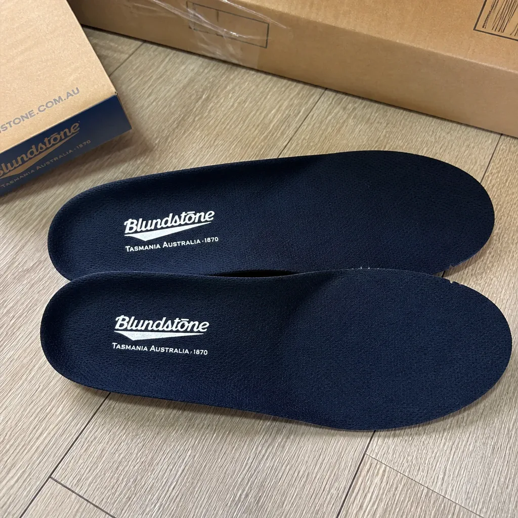 A pair of Blundstone Comfort Classic Footbed insoles next to their retail box on the floor