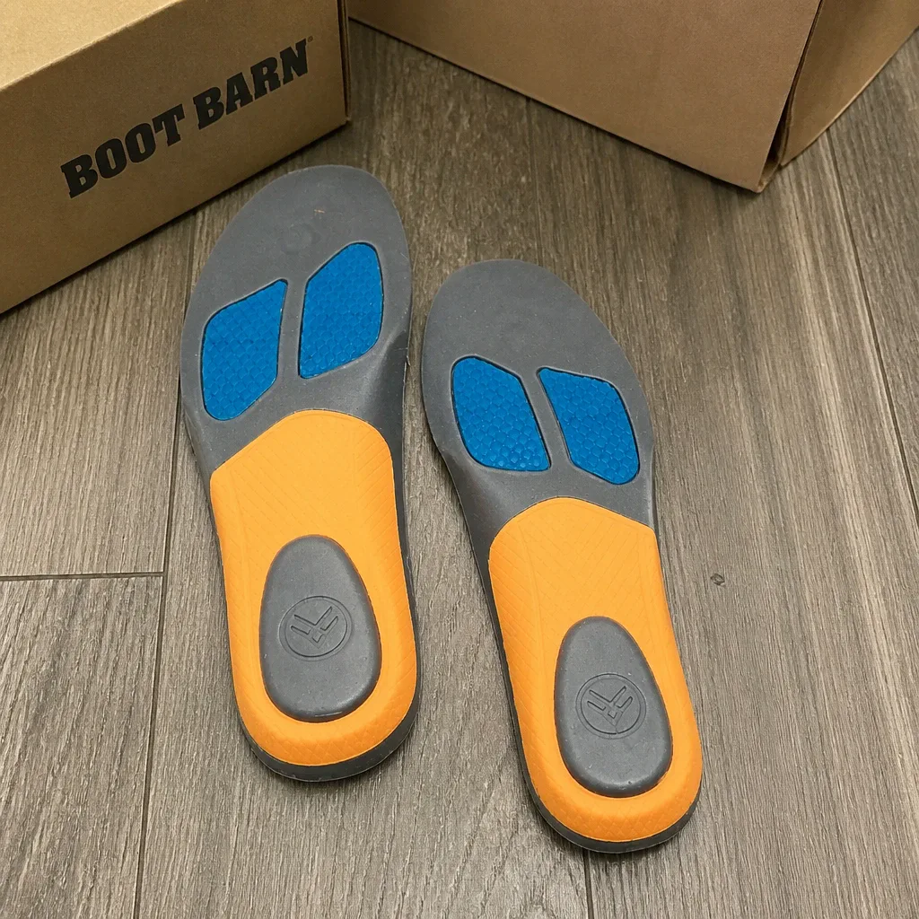 A pair of Hawx Ground Support Work Boot Insoles next to their retail box on the floor