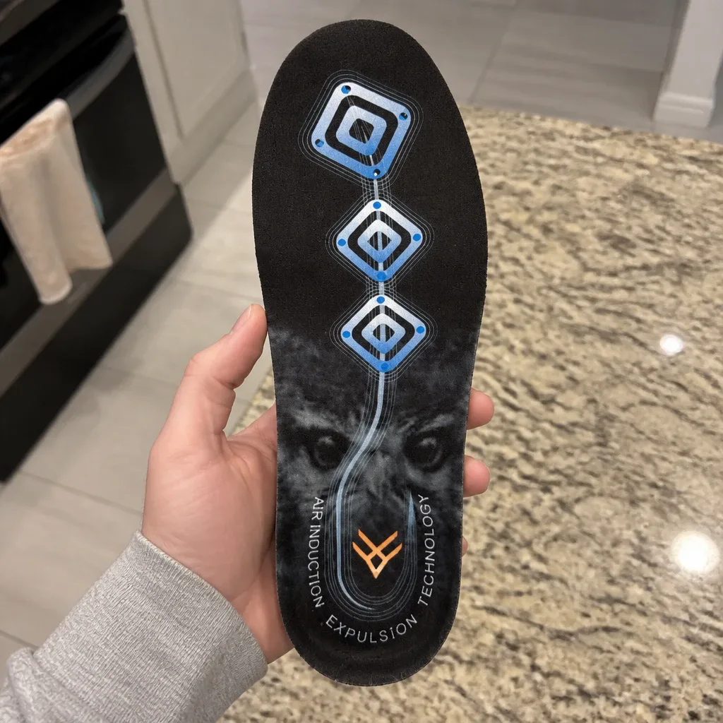 A hand holding a Hawx Ground Support Work Boot Insole to show the molded heel cup