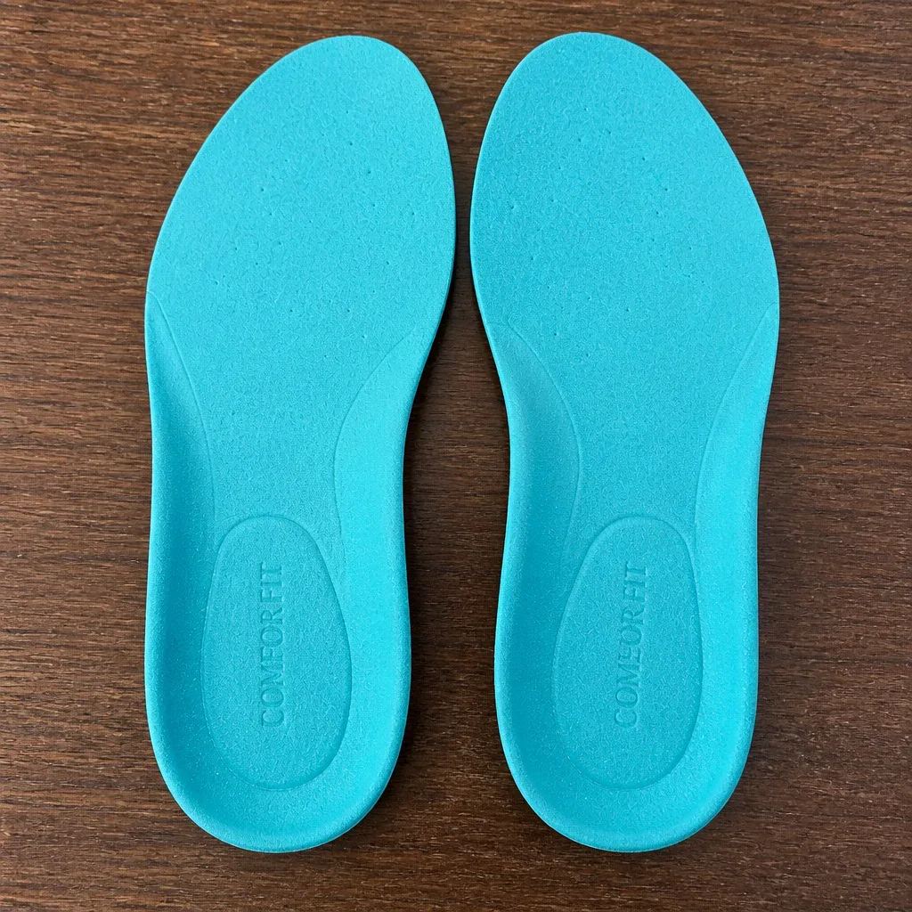 A pair of Comfort Fit Orthotics insoles on a kitchen table with packaging visible