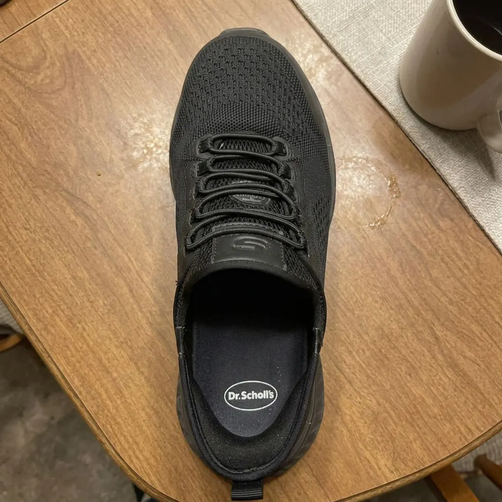 A Dr. Scholl's insole seated inside a black athletic shoe