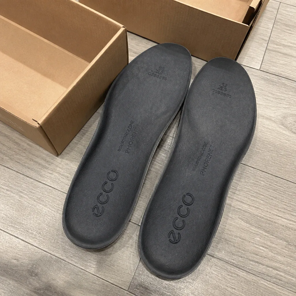 ECCO insole boxes on the floor next to the insoles
