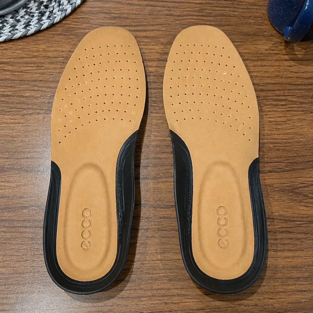 A pair of ECCO Comfort Supreme Leather insoles laid out on a kitchen table
