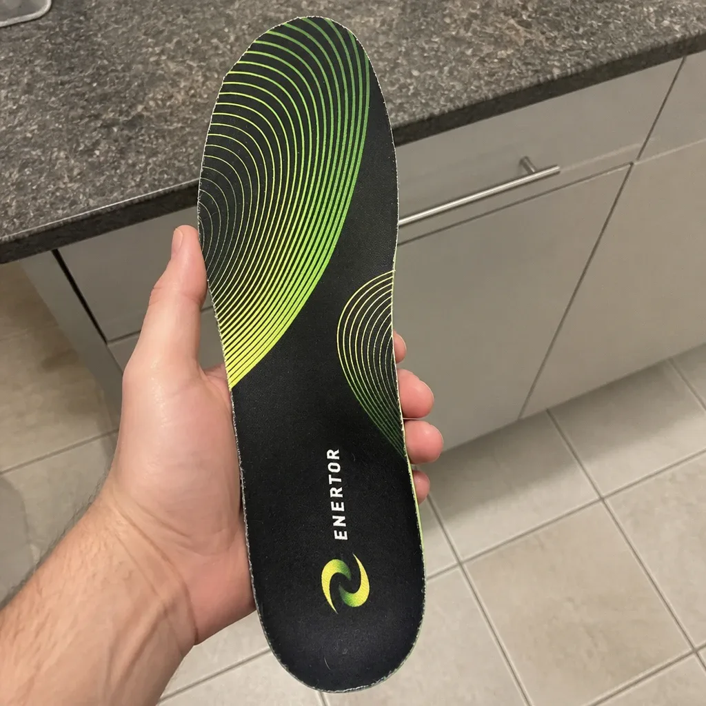 An Enertor PX1 Running Insole held in hand showing the heel cup and arch support