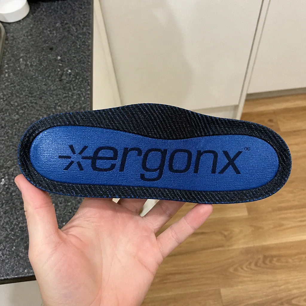 A close-up of the Ergonx Ultra Soft insole's top cover and arch post held in hand
