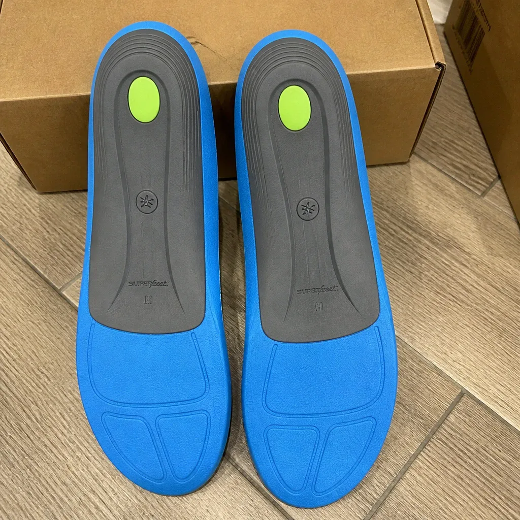 Fleet Feet Superfeet insole boxes on the floor next to the insoles