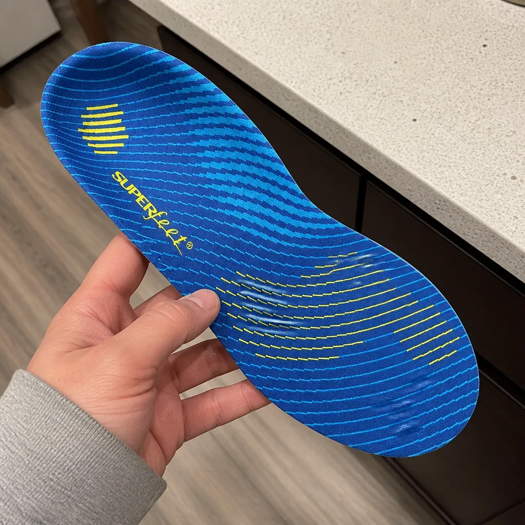 A Fleet Feet Superfeet Run Support High Arch insole held in hand showing the heel cup