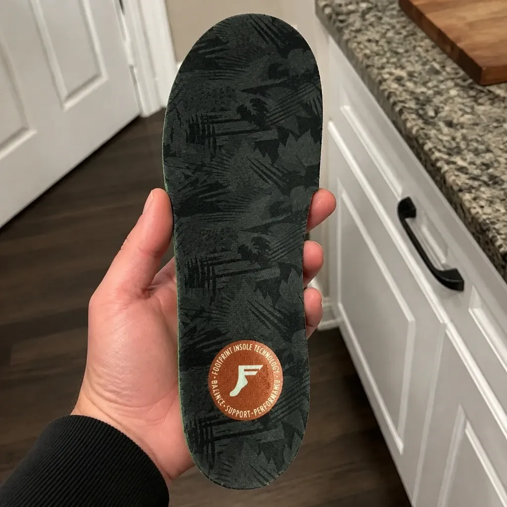 An FP Gamechangers Elite insole held in hand showing the arch chamber