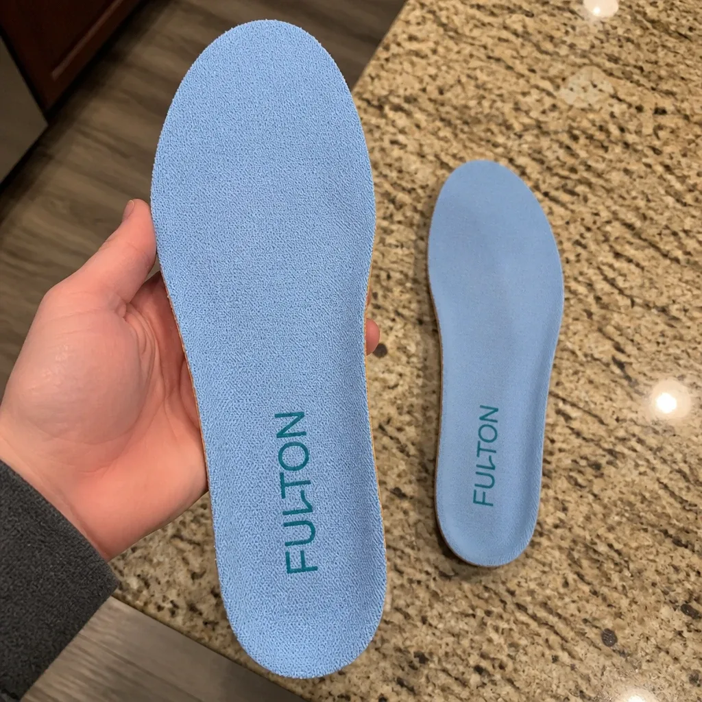 Fulton Athletic Insole held in hand next to its pair on a countertop