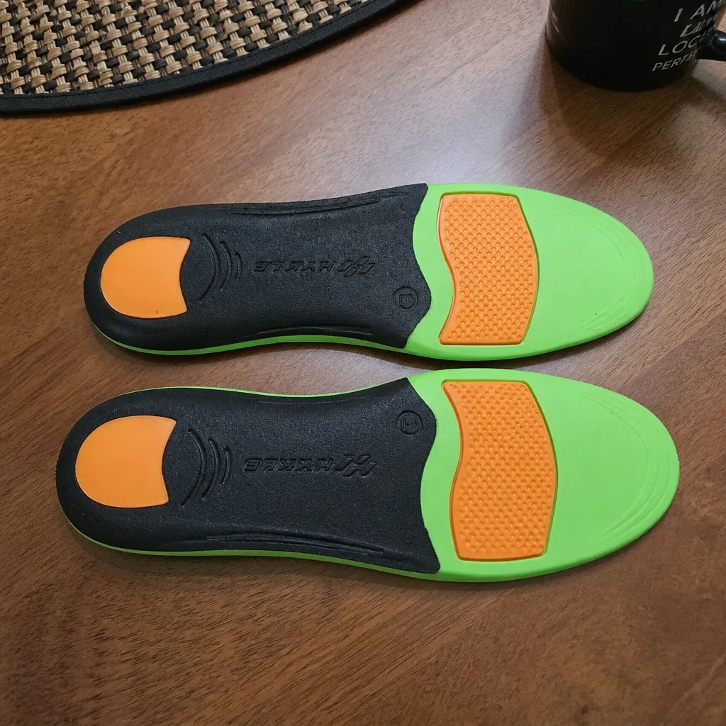The underside of a pair of HYKLE Impact Pro insoles on a table