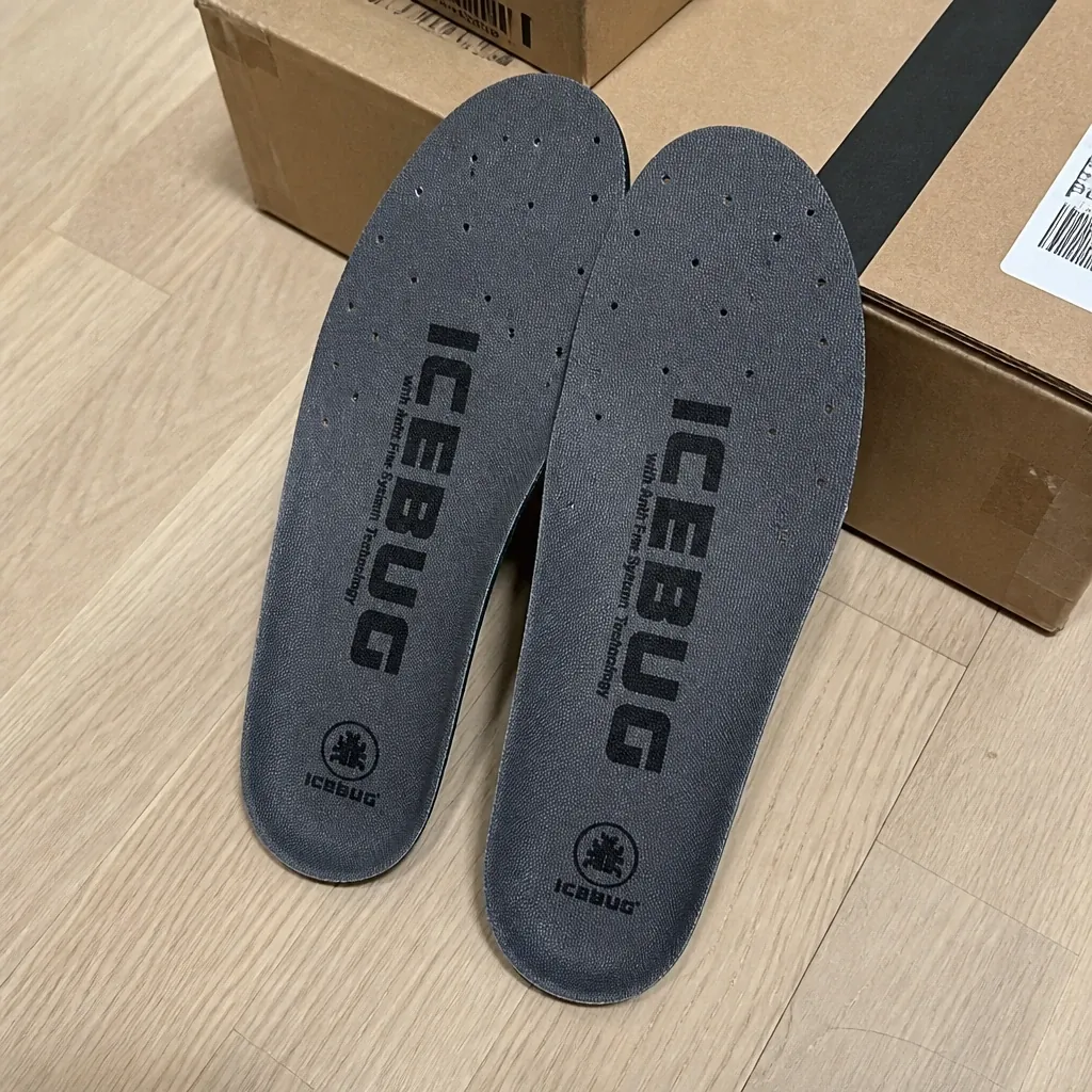 Icebug Comfort insoles on the floor next to shoe boxes