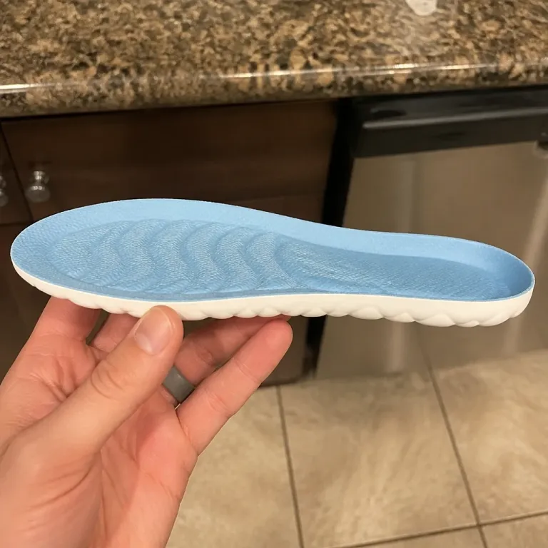 KANEEA insole held sideways to show its thickness